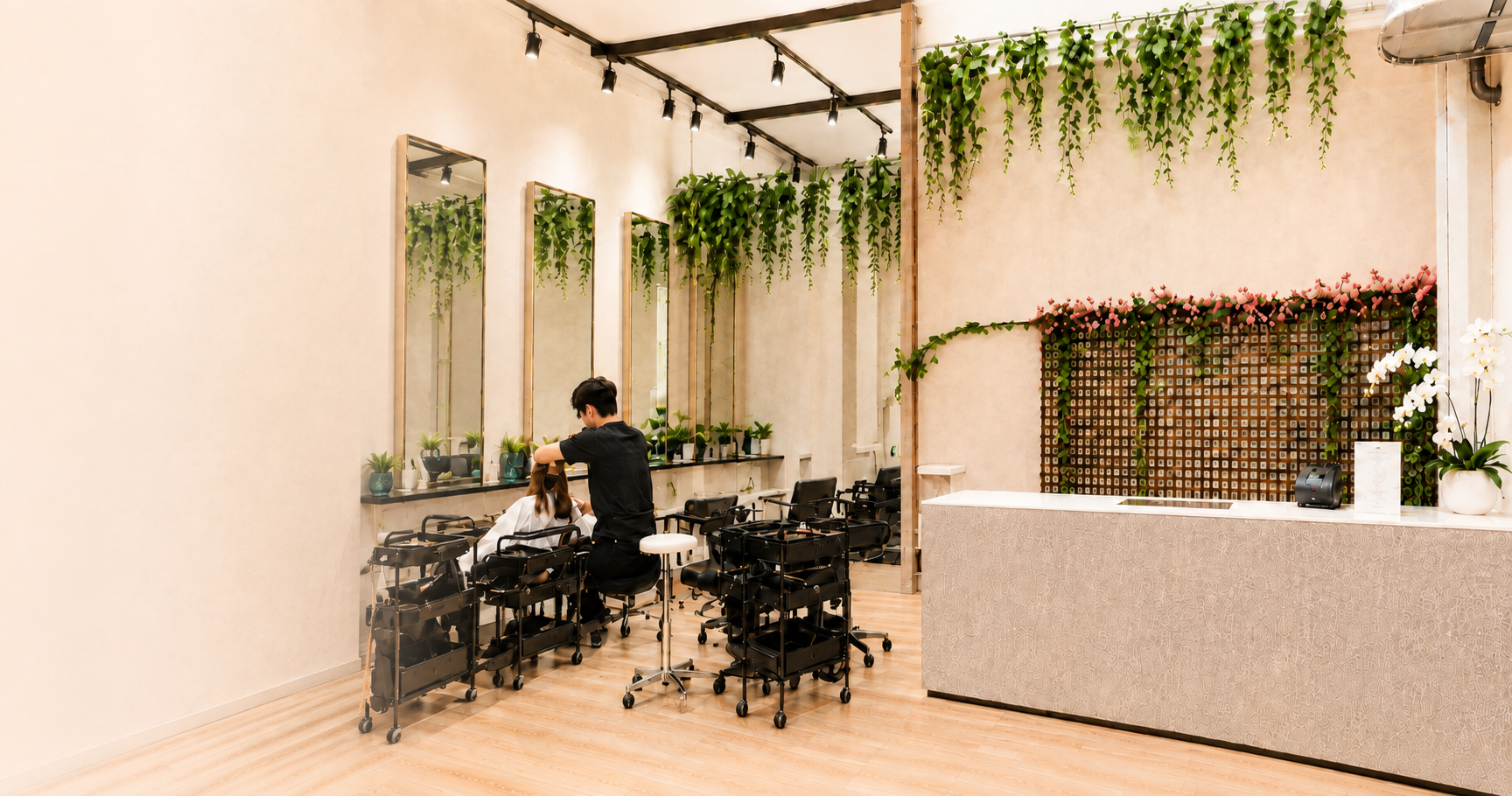 Bright interior of Bloom Hair Place with styling stations, greenery and the reception counter